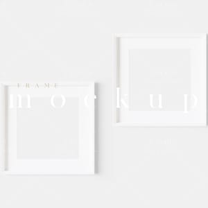 May include: Two white picture frames on a white wall. The frames are square and have a simple, modern design.