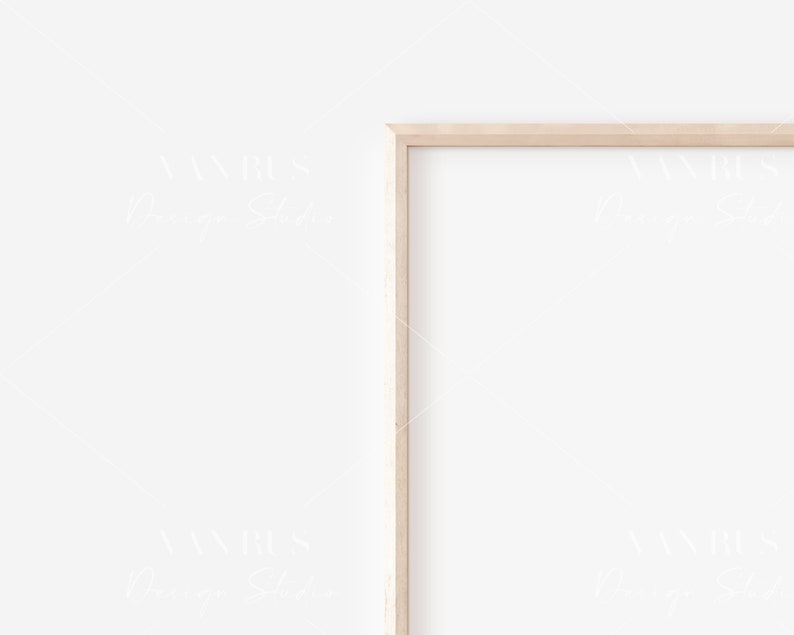May include: A simple, light wood picture frame with a white background. The frame is positioned on a white wall.