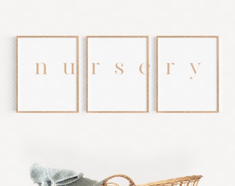 Puede incluir: Tres impresiones enmarcadas en madera que deletrean la palabra "nursery" en una fuente marrón claro sobre un fondo blanco. Un moisés de mimbre con una manta de punto azul claro está en primer plano.