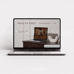 Może przedstawiać: Srebrny laptop wyświetlający makietę strony internetowej z tekstem "HEALTH FIRST". Na ekranie widać laptopa, biały przedmiot dekoracyjny i drewniany st&oacute;ł. Laptop jest otwarty i widoczna jest klawiatura.
