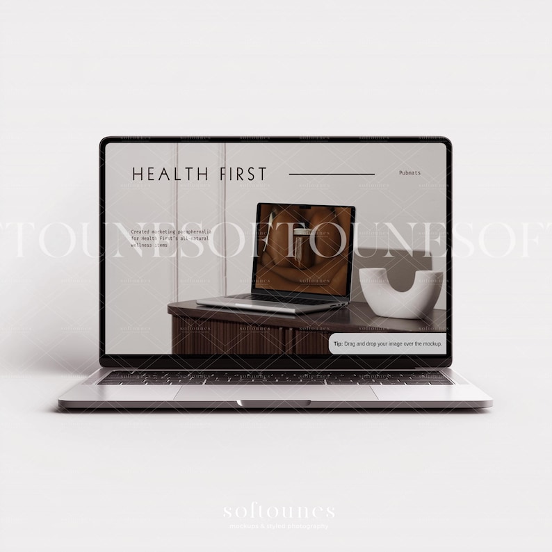 Może przedstawiać: Srebrny laptop wyświetlający makietę strony internetowej z tekstem "HEALTH FIRST". Na ekranie widać laptopa, biały przedmiot dekoracyjny i drewniany st&oacute;ł. Laptop jest otwarty i widoczna jest klawiatura.