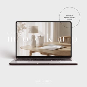 May include: A silver laptop displays a mockup scene with a lamp, vase, and open book on a wooden table. The screen shows a neutral-toned interior design. Text on the screen reads "LAPTOP mockup". A circle with the text "CHANGE BACKGROUND COLOR" is on the right.