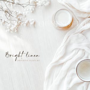 May include: A white linen fabric draped over a white wooden surface with two clear glass cups and the text "Bright linen Artistic Flatlay".
