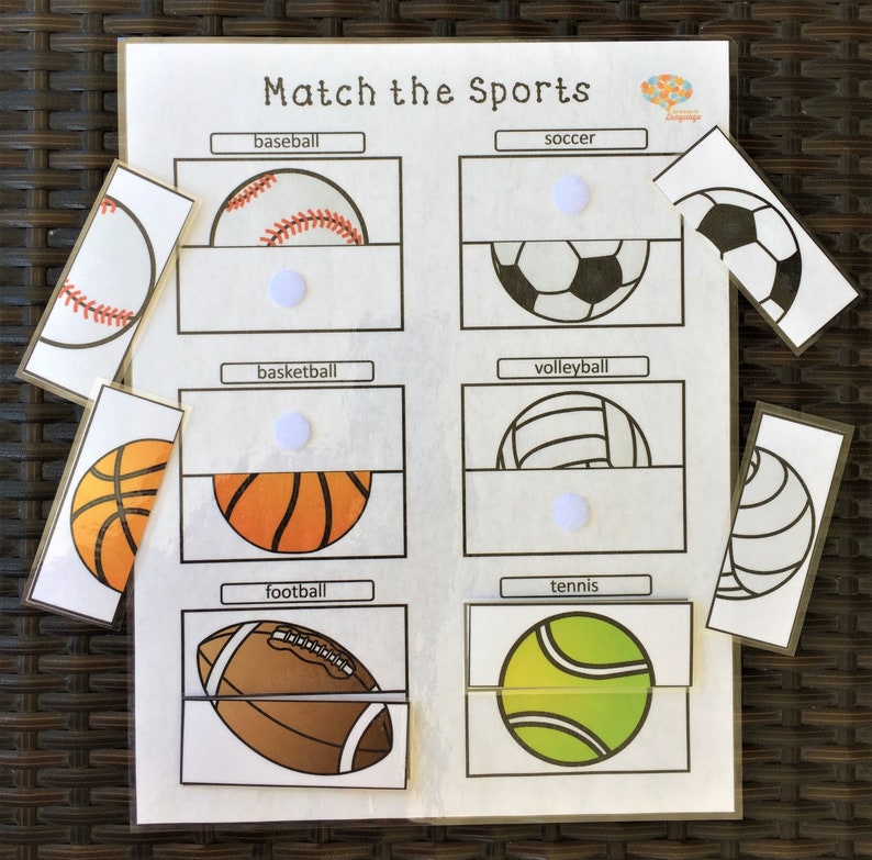 May include: A white sheet of paper with the title 'Match the Sports' printed at the top. The sheet is divided into six sections, each with a different sport name printed at the top: baseball, soccer, basketball, volleyball, football, and tennis. Each section has a picture of a half ball and a white circle in the middle. Below each section is a separate card with a full picture of the ball. The balls are: a baseball, a soccer ball, a basketball, a volleyball, a football, and a tennis ball.