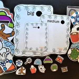 May include: A set of winter-themed educational flashcards with various images, including a gingerbread man, a polar bear, a snowman, a tree, a fireplace, a mug of hot chocolate, and boots. The flashcards are labeled with the words "big", "medium", and "small".