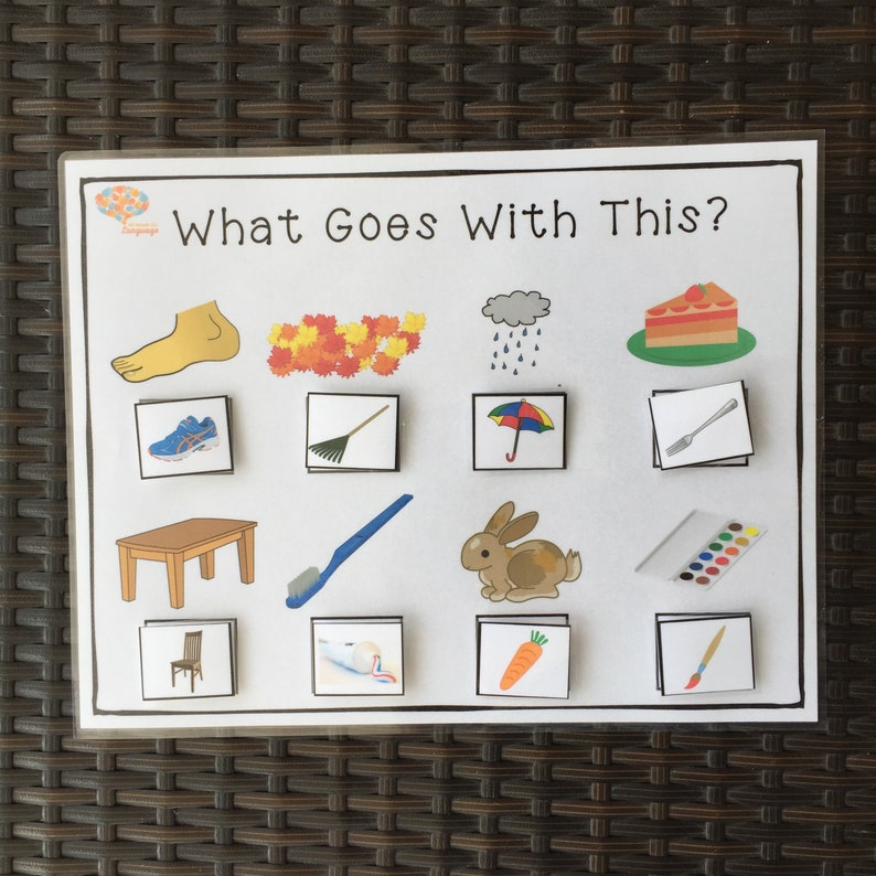 May include: A colorful educational game for kids with the text "What Goes With This?"  The game features images of a foot, leaves, rain, cake, shoes, a rake, an umbrella, a fork, a table, a toothbrush, a rabbit, paint, a chair, toothpaste, a carrot, and a paintbrush.