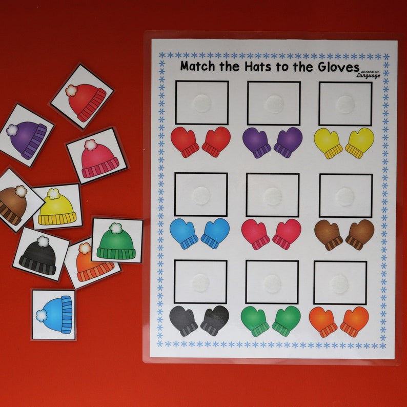 Puede incluir: Un juego educativo para ni&ntilde;os con ilustraciones de gorros y guantes. El juego incluye tarjetas de emparejamiento con gorros de diferentes colores y un tablero con guantes a juego. El texto en el tablero dice "Match the Hats to the Gloves".