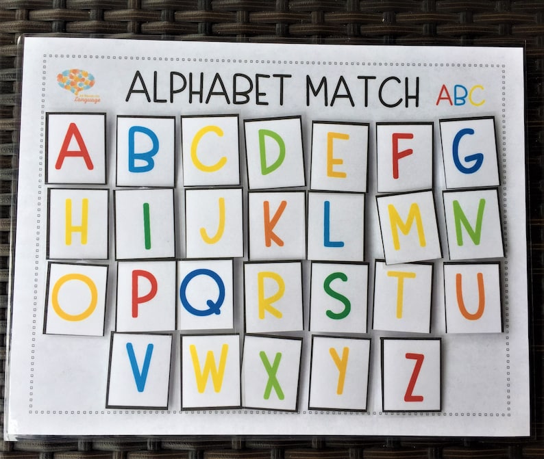 May include: A colorful alphabet matching game with the letters A through Z printed on individual squares. The letters are in different colors and are arranged in rows on a white background. The title "Alphabet Match ABC" is printed at the top of the game.