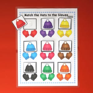 May include: A laminated educational game with the text "Match the Hats to the Gloves." The game features colorful illustrations of hats and mittens in various colors, including red, purple, yellow, blue, pink, brown, black, green, and orange.