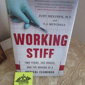 May include: A book titled "Working Stiff: Two Years, 262 Bodies, and the Making of a Medical Examiner" by Judy Melinek, M.D. and T.J. Mitchell. The book cover features a gloved hand holding a scalpel.