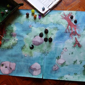 May include: A watercolor map with a blue ocean, green islands, and red trees. There are black miniature figures on the islands and dice scattered around the map.