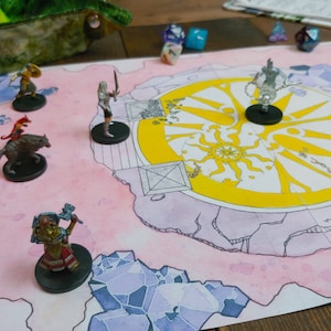 May include: A tabletop role-playing game setup featuring a pink and yellow map with miniature figures. The map has a sun design and crystal-like borders. Several dice are scattered around the map, suggesting gameplay.