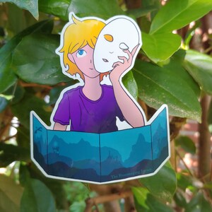 Puede incluir: Una pegatina con una ilustración de una persona sosteniendo una máscara blanca. La persona tiene el pelo rubio y lleva una camiseta morada. Un paisaje azul y turquesa está en la parte inferior de la pegatina. El texto en la parte inferior dice "The Hummingbird Ferret."