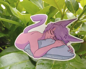May include: A purple and pink cartoon character with a long tail is sleeping on a blue pillow. The character has a long, pointed ear and is holding the pillow with one hand. The character is on a green leafy background. The text "@The Rummaging Ferret" is at the bottom of the image.