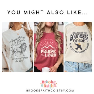 May include: Three graphic t-shirts with inspirational quotes. The first is cream-colored with a lion graphic and the text "You've got a lion inside of those lungs, get up & praise the Lord." The second is red with "Praise the Lord." The third is cream with "I will sing of the goodness of God."
