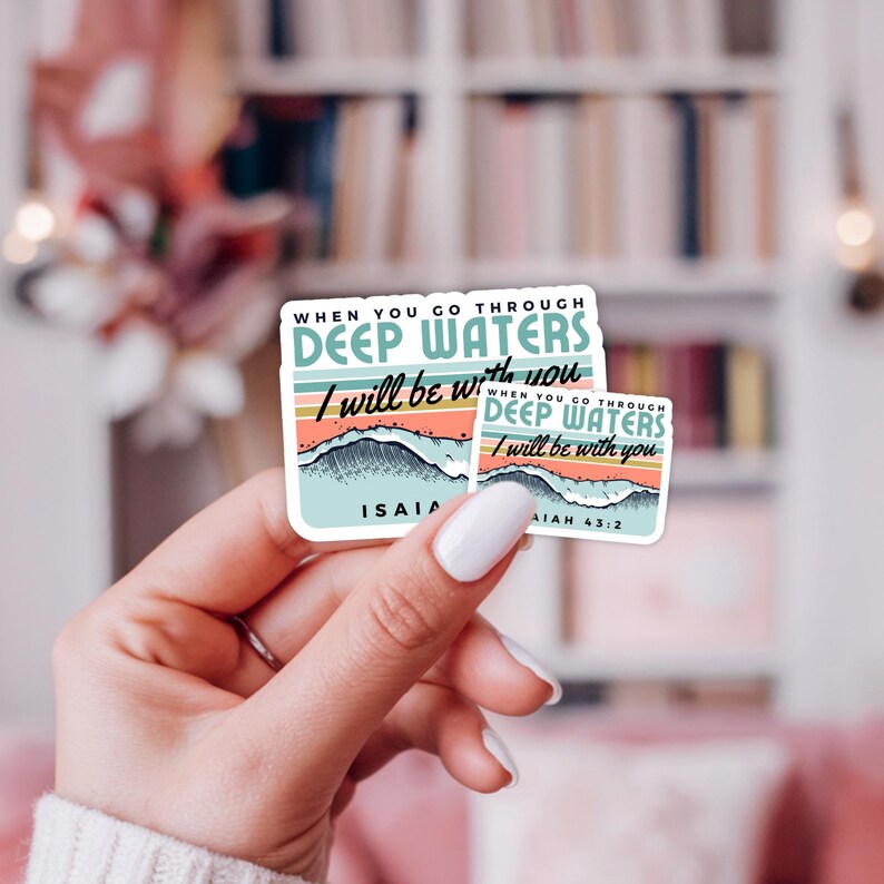 May include: Two stickers with the text "WHEN YOU GO THROUGH DEEP WATERS I will be with you". The stickers have a design of waves and a colorful sunset. The smaller sticker has the text "AIAH 43:2".