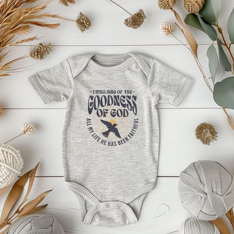 May include: A grey baby onesie with a graphic print of a bird and the text "I will sing of the goodness of God, all my life he has been faithful".