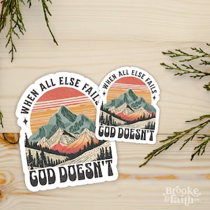 May include: Two stickers with a mountain landscape design. The stickers feature a sunset, mountains, and trees. The text on the stickers reads "When all else fails, God doesn't."