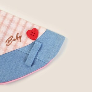 May include: A blue denim and pink gingham dog collar with a red heart button and the word "Baby" embroidered on it.