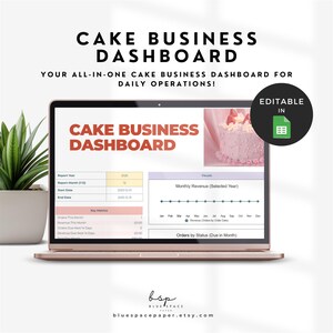 May include: A rose gold laptop displays a cake business dashboard with charts and data. The screen shows the words "CAKE BUSINESS DASHBOARD" in large text. A green plant in a white pot is on the left. The dashboard is editable in Excel.