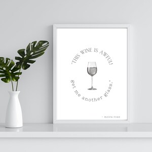 K&ouml;nnte beinhalten: Ein wei&szlig;er gerahmter Druck mit einer Schwarzwei&szlig;illustration eines Weinglases und dem Text "Dieser Wein ist schrecklich! Bring mir ein anderes Glas." - Moira Rose
