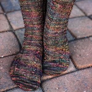 May include: A pair of colourful knitted socks with a cable knit pattern. The socks are made with a variegated yarn that creates a unique and eye-catching design.
