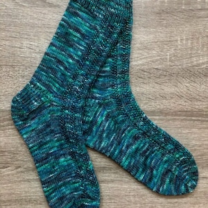May include: A pair of teal and green striped socks with a knitted texture.