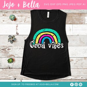 Op de afbeelding: Een zwart tanktop met een regenboogontwerp en de tekst "Good vibes" in wit. De regenboog is gemaakt van groene, gele, roze en blauwe strepen.