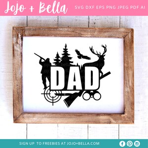 May include: A framed black and white graphic with the word "DAD" in bold letters. The design includes silhouettes of a hunter, trees, an eagle, a deer, a target, an axe, and binoculars. The frame is made of light brown wood.