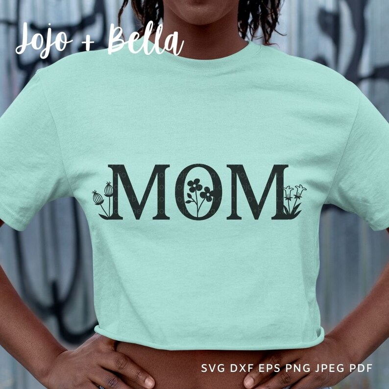 May include: A light blue t-shirt with the word "MOM" in black letters. Each letter has a floral design inside. The text "SVG DXF EPS PNG JPEG PDF" is at the bottom of the image.