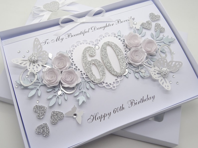 May include: A handmade 60th birthday card in a white box. The card features silver glitter numbers, paper roses, butterflies, and hearts. Text includes "To My Beautiful Daughter Beverly" and "Happy 60th Birthday".