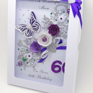 May include: A white card with a purple and silver butterfly, flowers, and glitter. The card says "To A Wonderful Mum" and "On Your 60th Birthday".