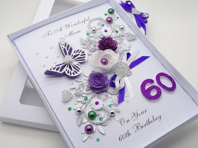 May include: Purple and white handmade birthday card with a butterfly, flowers, glitter, and the text "To A Wonderful Mum On Your 60th Birthday".