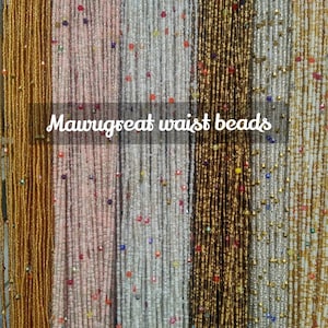 May include: A variety of waist beads in different colors, including gold, silver, and pink. The beads are strung on thin cords and are arranged in rows. The text "Mawugreat waist beads" is visible in the center of the image.