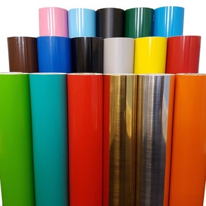 May include: Assortment of vinyl rolls in various colours, including green, turquoise, red, gold, silver, and orange. The rolls are arranged in a pyramid shape, with the top row containing pink, light blue, black, green, and blue rolls.