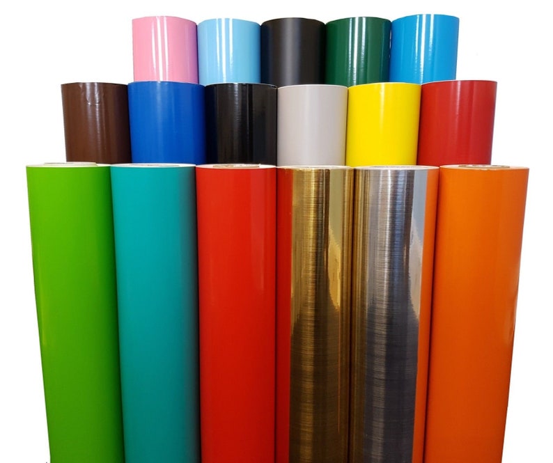 May include: Assortment of vinyl rolls in various colours, including green, turquoise, red, gold, silver, and orange. The rolls are arranged in a pyramid shape, with the top row containing pink, light blue, black, green, and blue rolls.