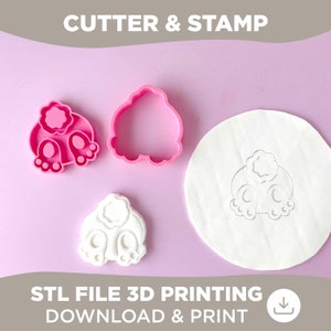 Könnte beinhalten: Zwei rosa Plastik-Ausstecher und ein weißer Fondant-Stempel in Form eines Hasenhinterteils. Die Ausstecher und der Stempel befinden sich auf einer rosa Oberfläche. Der Text "CUTTER & STAMP" befindet sich oben im Bild. Der Text "STL FILE 3D PRINTING DOWNLOAD & PRINT" befindet sich unten im Bild.