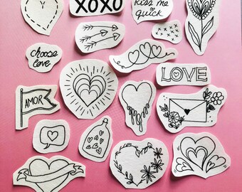May include: A collection of 15 black and white hand-drawn heart-shaped stickers with various designs, including XOXO, kiss me quick, choose love, AMOR, LOVE, and a heart with flowers. The stickers are on a pink background.