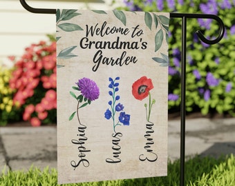 May include: Welcome to Grandma's Garden garden flag featuring a floral design and the names Sophia, Lucas, and Emma. The flag is beige with green leaves and flowers in shades of purple, blue, and red.