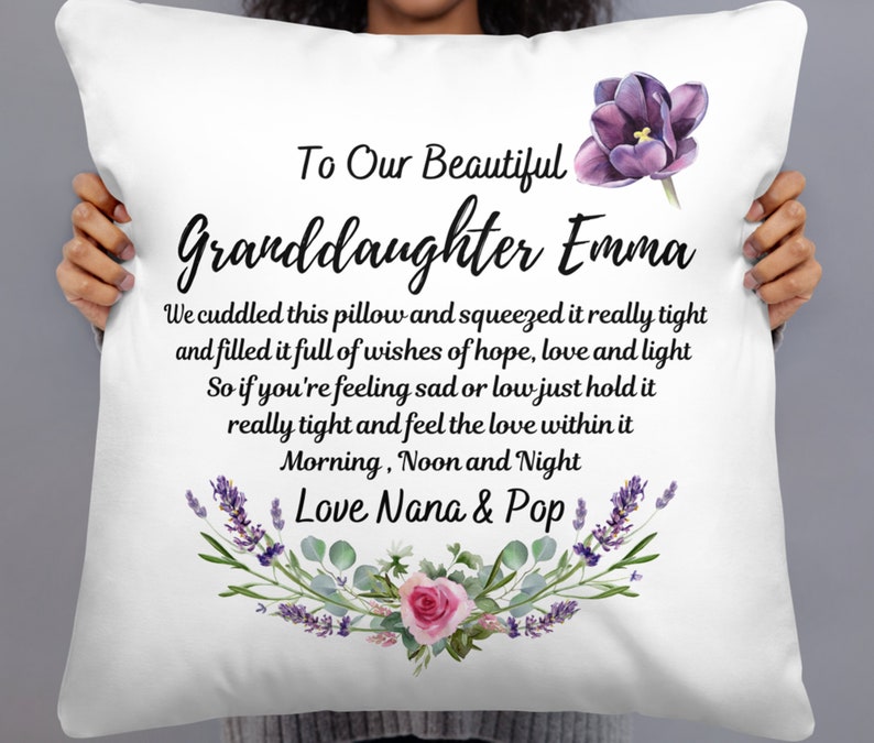 May include: White pillow with a floral design and the text "To Our Beautiful Granddaughter Emma" and "We cuddled this pillow and squeezed it really tight and filled it full of wishes of hope, love and light So if you're feeling sad or low just hold it really tight and feel the love within it Morning, Noon and Night Love Nana & Pop"