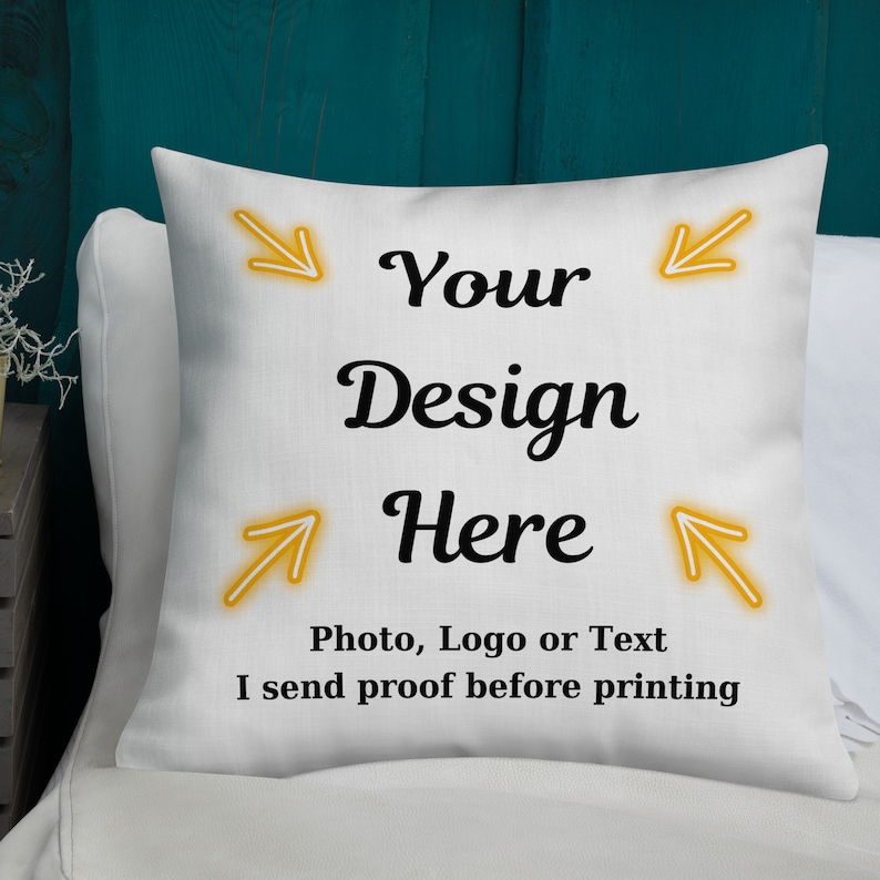 K&ouml;nnte beinhalten: Wei&szlig;es quadratisches Kissen mit dem Text "Your Design Here" in schwarzer Schrift. Das Kissen hat auch den Text "Photo, Logo or Text I send proof before printing". Gelbe Pfeile zeigen zur Mitte des Kissens.
