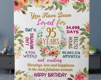 May include: A white floral patterned blanket with the text "You Have Been Loved for 95 Years" and a list of time units in days, hours, weeks, and minutes. The text "That is 1,140 Months" is also included. The blanket has a pink, white, and green floral design.