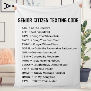 Pode incluir: Cobertor branco com texto preto que diz "Senior Citizen Texting Code" e lista as abreviações comuns de mensagens de texto para idosos e seus significados.