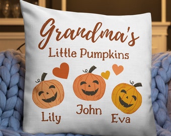 May include: White throw pillow with the text "Grandma's Little Pumpkins" and three smiling jack-o'-lantern faces with the names Lily, John, and Eva underneath.