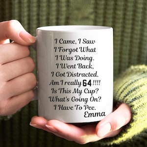 Puede incluir: Taza de cerámica blanca con texto negro que dice "Vine, vi, olvidé lo que estaba haciendo. Volví, me distraje. ¿Realmente tengo 64!!!! Es esta mi taza? ¿Qué está pasando? Tengo que ir al baño. Emma"
