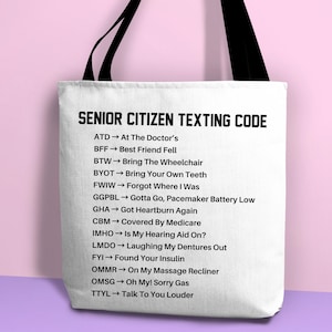 May include: White tote bag with black handles and black text that reads "Senior Citizen Texting Code" and lists abbreviations and their meanings, such as "ATD - At The Doctor's", "BFF - Best Friend Fell", and "BTW - Bring The Wheelchair".