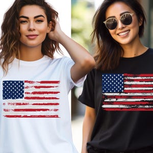 May include: Two women wearing t-shirts with a distressed American flag design. One shirt is white, the other is black. The flag features a blue square with white stars and red and white stripes.