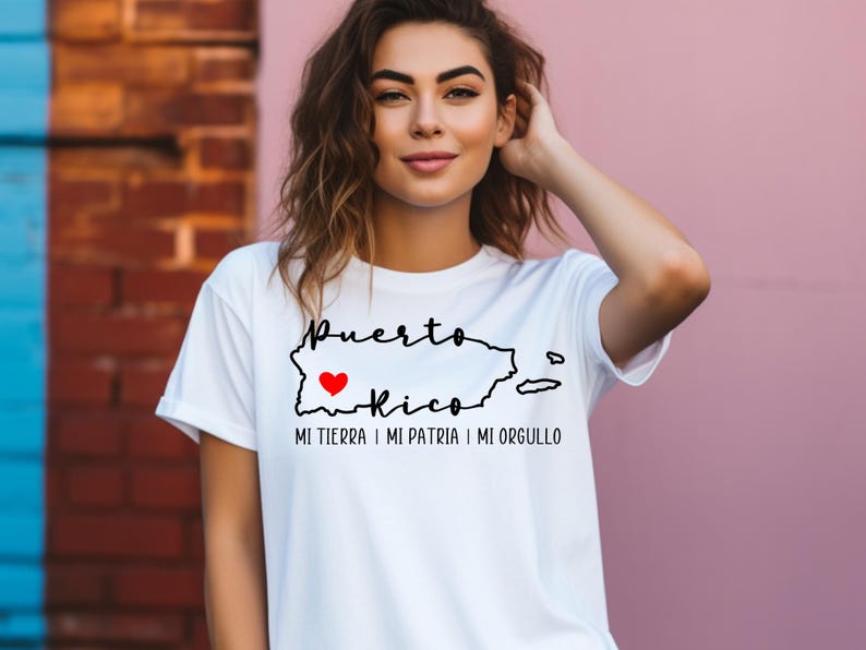 Puede incluir: Camiseta blanca con un contorno negro de Puerto Rico y las palabras "Puerto Rico" y "Mi tierra, mi patria, mi orgullo". Un coraz&oacute;n rojo est&aacute; dentro del contorno de Puerto Rico.