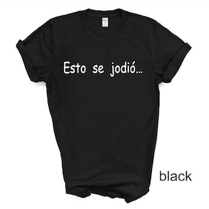 May include: Black t-shirt with the text "Esto se jodió..." printed in white.