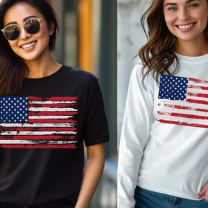 May include: Black t-shirt and white long-sleeve shirt featuring a distressed American flag design. The flag has a blue field with white stars and red and white stripes. The shirts are casual wear.